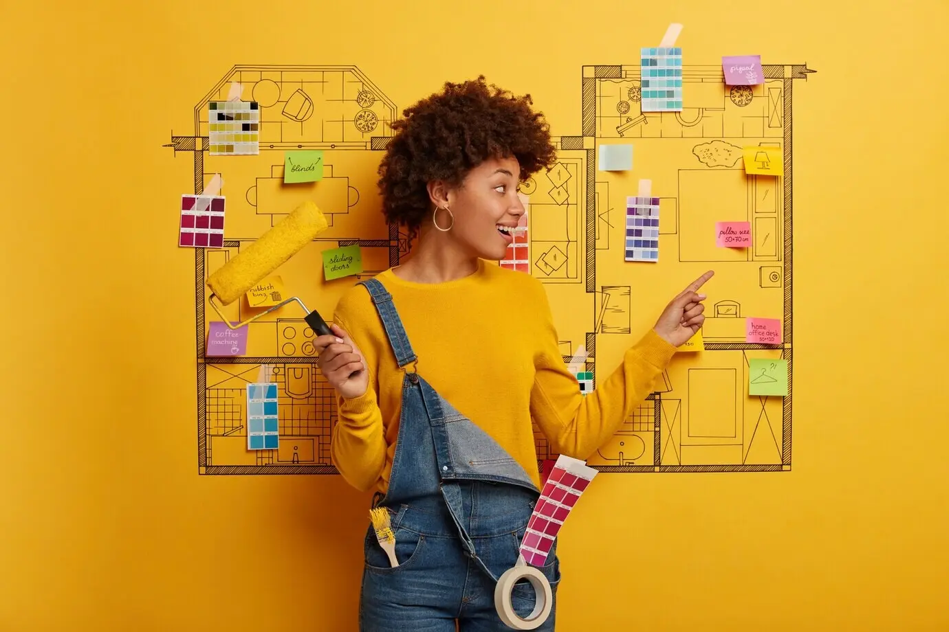 Junge Frau steht neben einer Skizze eines Hausentwurfs, bereit für die Renovierung.